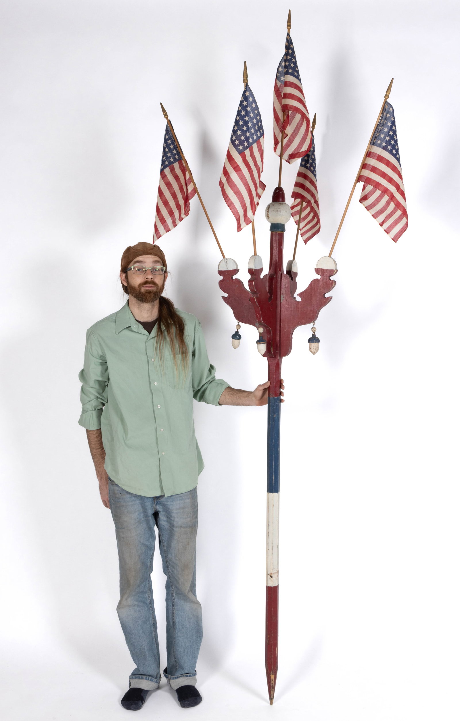 AMERICAN FOLK ART PATRIOTIC PAINTED WOODEN FLAG HOLDER: AMERICAN FOLK ART PATRIOTIC PAINTED WOODEN FLAG HOLDER, unusual form, thought to be a parade route marker, retaining original red, white, and blue surface, fitted with whimsical acorn pendant devices,