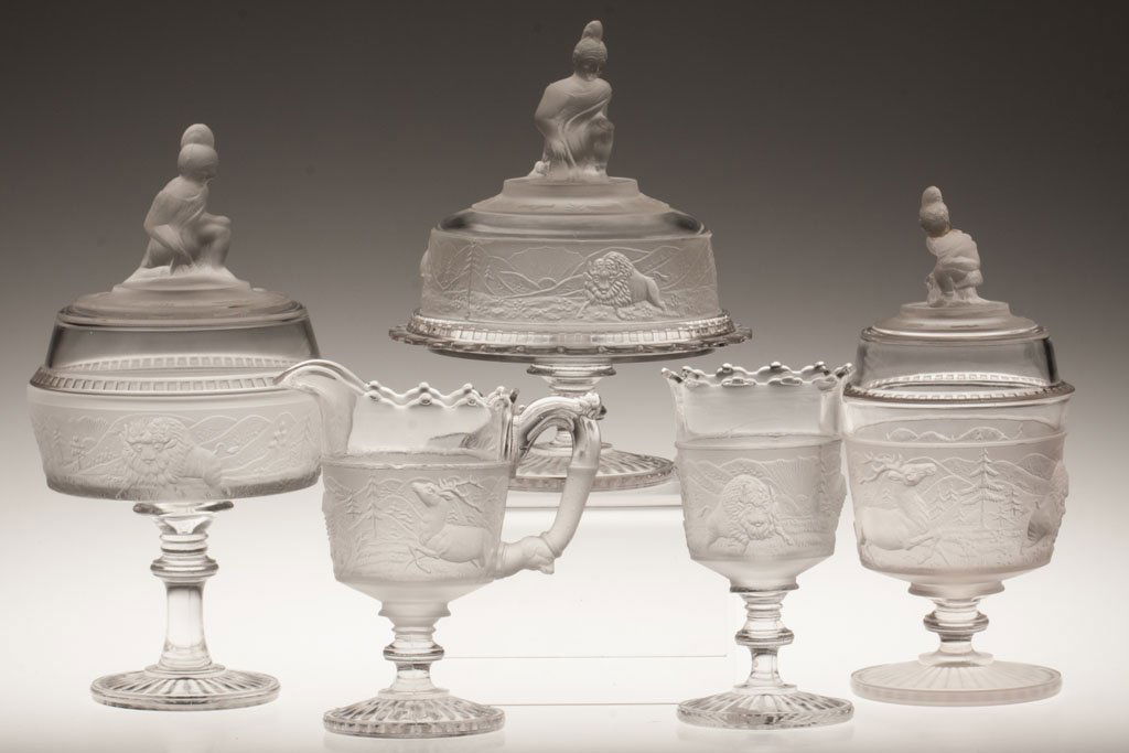 WESTWARD HO FOUR-PIECE TABLE SET: WESTWARD HO FOUR-PIECE TABLE SET, colorless, comprising a covered butter dish, covered sugar bowl, creamer and spooner. Together with reproduction compote. Five pieces total. Fourth quarter 19th and 2