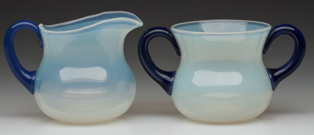 FRY FOVAL CREAMER AND SUGAR: FRY FOVAL CREAMER AND SUGAR, opalescent with applied Delft blue handles, shape #2000, each with polished pontil mark. H. C. Fry Glass Co. Circa 1925. 3" and 3 1/2" H. Provenance: Collection of the lat