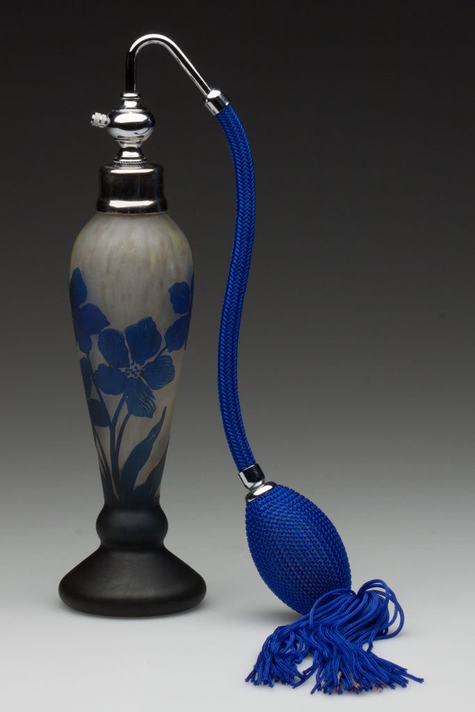 SIGNED DAUM NANCY CAMEO DRESSER BOTTLE: SIGNED DAUM NANCY CAMEO DRESSER BOTTLE, blue cut to a mottled ground, multi-bloom floral decoration, fitted with a modern metal collar and screw in atomizer. France. First quarter 20th century. 6" H t