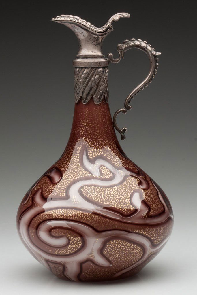 LOETZ FEDERZEICHNUNG GLASS EWER: LOETZ FEDERZEICHNUNG GLASS EWER, cased chocolate brown with gilt tracery decoration, air-trap pearlized octopus pattern with connecting trails, base handwritten "Patent", fitted with a silver-plate hi
