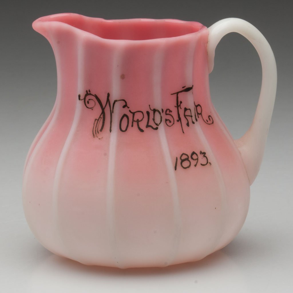 WORLD'S FAIR PEACHBLOW CREAMER: WORLD'S FAIR PEACHBLOW CREAMER, plush finish, body with 12 pronounced ribs and applied handle, "World's Fair / 1893" in gold script, rough pontil mark. Probably Libbey Glass Co./New England Glass Co.,