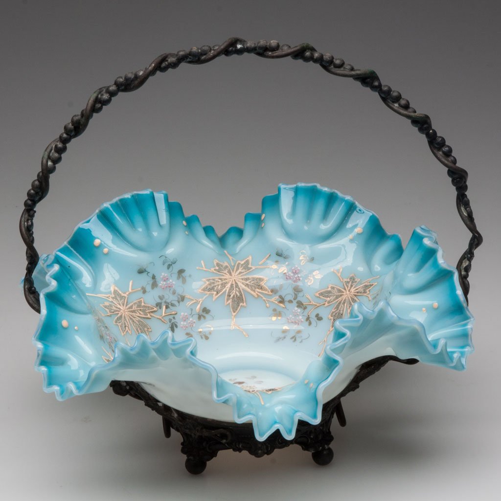 VICTORIAN DECORATED CASED GLASS BRIDE'S BASKET: VICTORIAN DECORATED CASED GLASS BRIDE'S BASKET, shaded blue with polychrome enamel foliate decoration, pattern crimped and ruffled rim, ground pontil mark, fitted in a quadruple-plate frame marked for