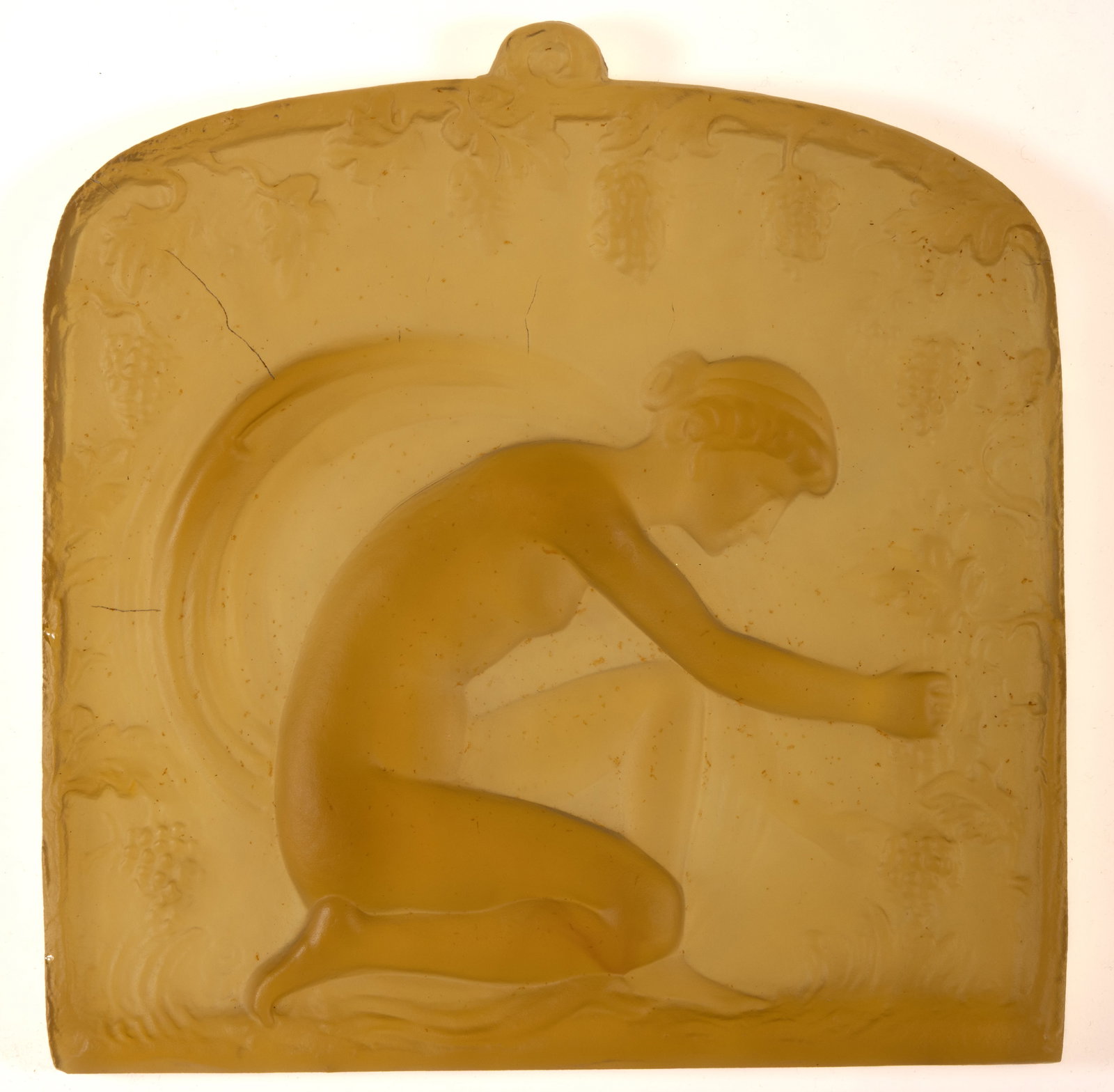 STEUBEN KNEELING WOMAN ART GLASS PLAQUE: STEUBEN KNEELING WOMAN ART GLASS PLAQUE, amber, shape 8418, depicting a woman picking grapes. Steuben Glass Works. Circa 1930. 8 7/8" x 9 1/2".Literature: Parallels Dimitroff