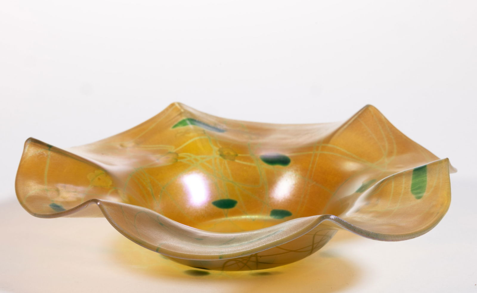 STEUBEN ATTRIBUTED MILLEFIORI AND VINE IRIDESCENT ART GLASS DISH: STEUBEN ATTRIBUTED MILLEFIORI AND VINE IRIDESCENT ART GLASS DISH, Gold Aurene with green decoration and clusters of white millefiori canes representing flowers, tooled rim, polished pontil mark. Steub