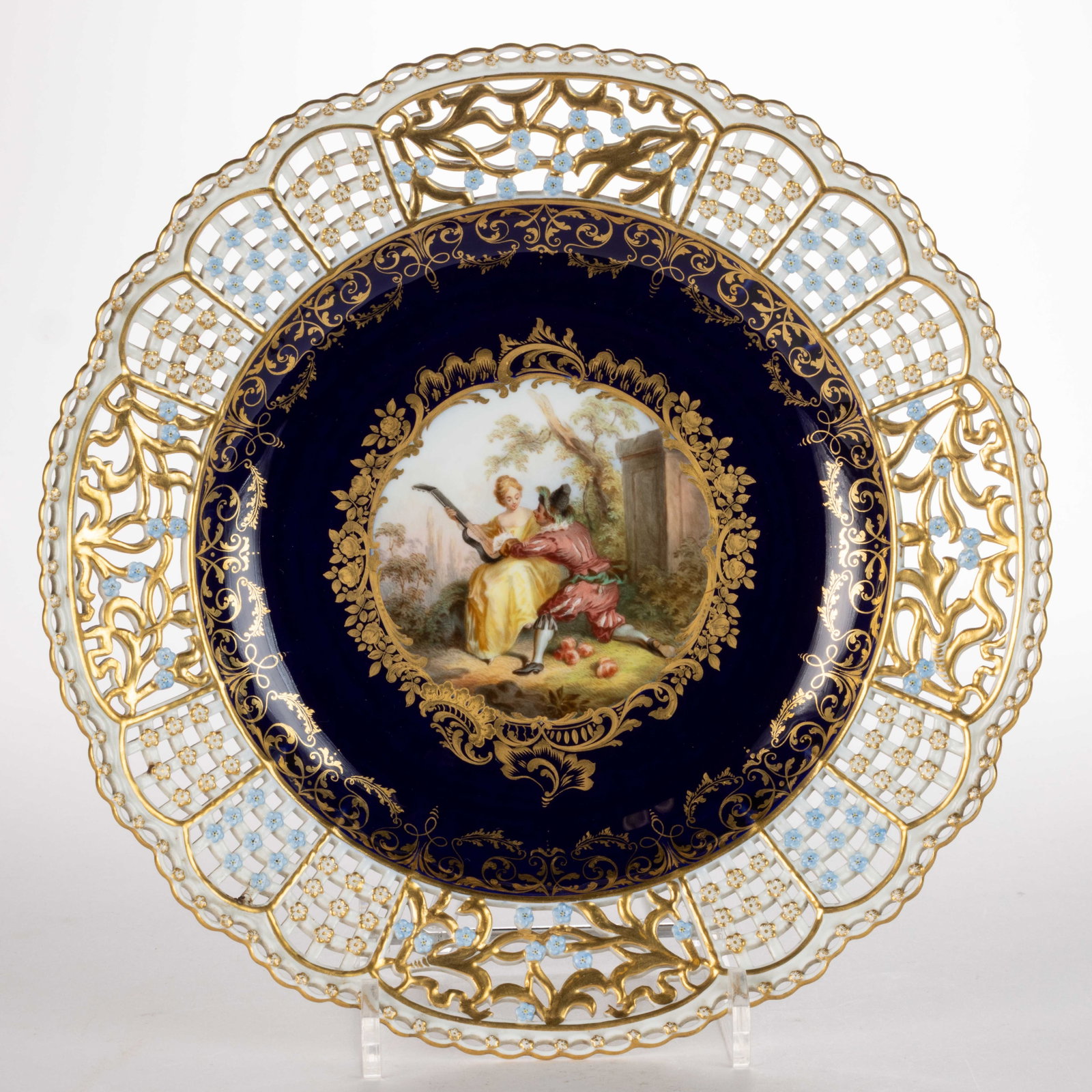 GERMAN MEISSEN PORCELAIN HAND-PAINTED RETICULATED CABINET PLATE: GERMAN MEISSEN PORCELAIN HAND-PAINTED RETICULATED CABINET PLATE, having polychrome hand-painted scene featuring a man on one knee beside a sitting woman holding a stringed instrument with cobalt surro