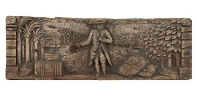BRITISH COLONIAL CARVED WOODEN PLAQUE: BRITISH COLONIAL CARVED WOODEN PLAQUE, carved from a single piece of oak, depicting a wealthy plantation owner, possibly in Jamaica or another 18th century British colony, standing in front of hi