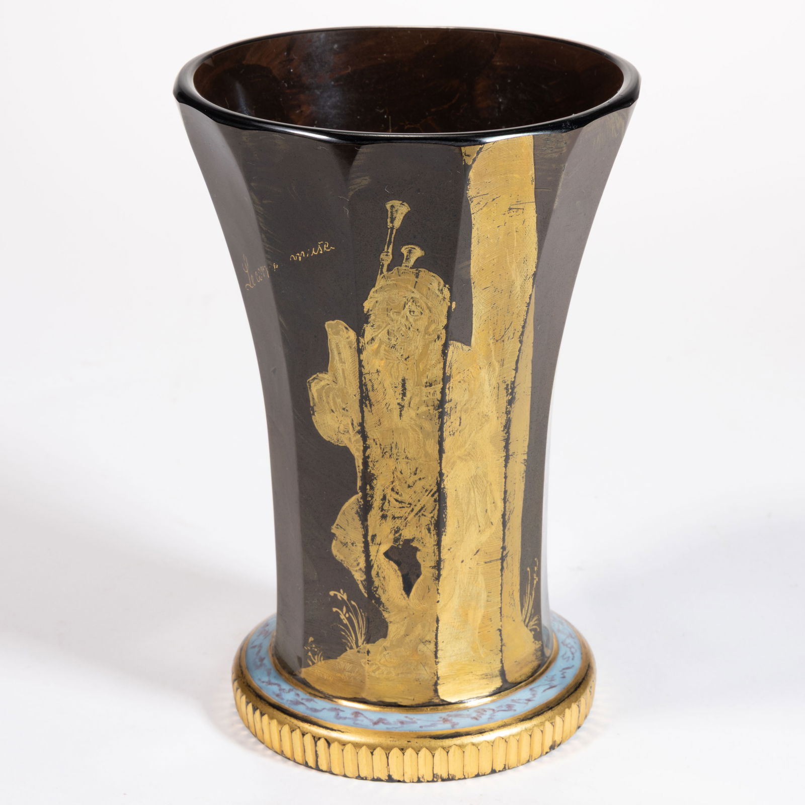 FRENCH AGATE AND GILT DECORATED GLASS BEAKER: FRENCH AGATE AND GILT DECORATED GLASS BEAKER, brown agate, flaring form with 12 vertical cut columns, gilt decoration depicting a musician with bagpipes next to the tree trunk, stating "Le corne-
