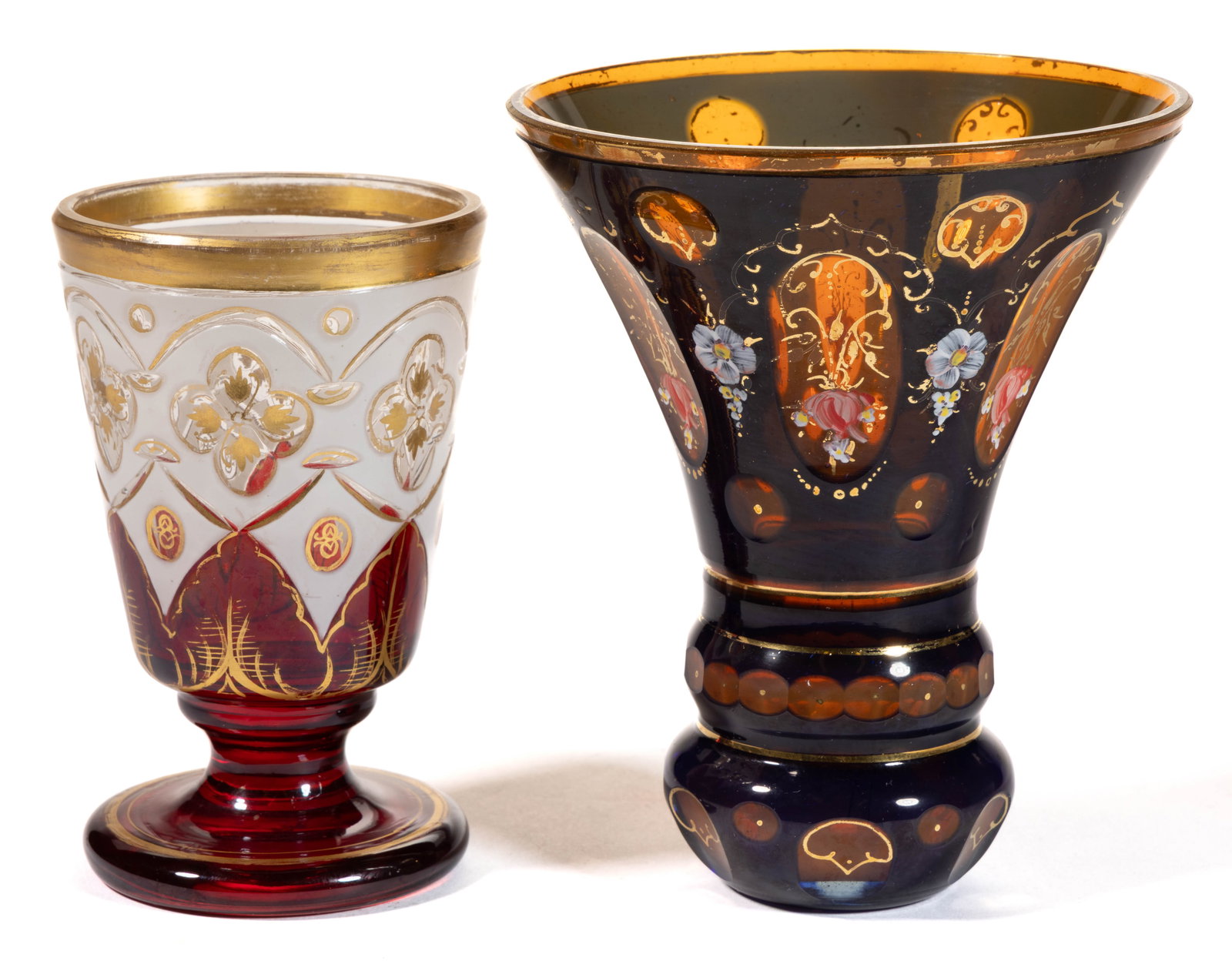 BOHEMIAN CUT-OVERLAY AND GILT DECORATED GLASS BEAKERS / DRINKING GLASSES, LOT OF TWO: BOHEMIAN CUT-OVERLAY AND GILT DECORATED GLASS BEAKERS / DRINKING GLASSES, LOT OF TWO, comprising one smaller footed example cut from opal to colorless with ruby staining around the foot and lower half