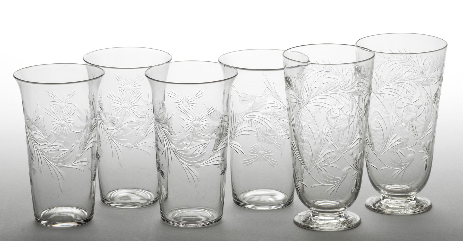 STEUBEN CUT ART GLASS TUMBLERS, LOT OF SIX: STEUBEN CUT ART GLASS TUMBLERS, LOT OF SIX, colorless, comprising two footed tumblers with an intricate fruit pattern, and four standard tumblers with flaring rims having floral cutting, most having s