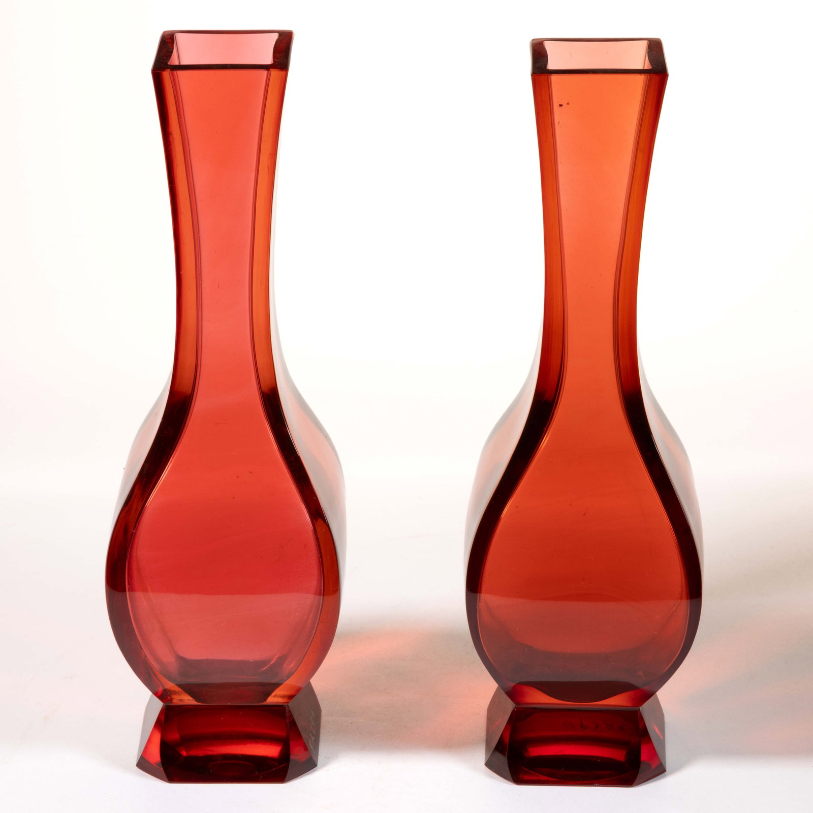 BACCARAT ATTRIBUTED RUBY GLASS PAIR OF VASES: BACCARAT ATTRIBUTED RUBY GLASS PAIR OF VASES, ruby, four panelled baluster form with a squared rim, square cut foot, polished pontil marks. The Compagnie des Verreries et Cristalleries de Baccara