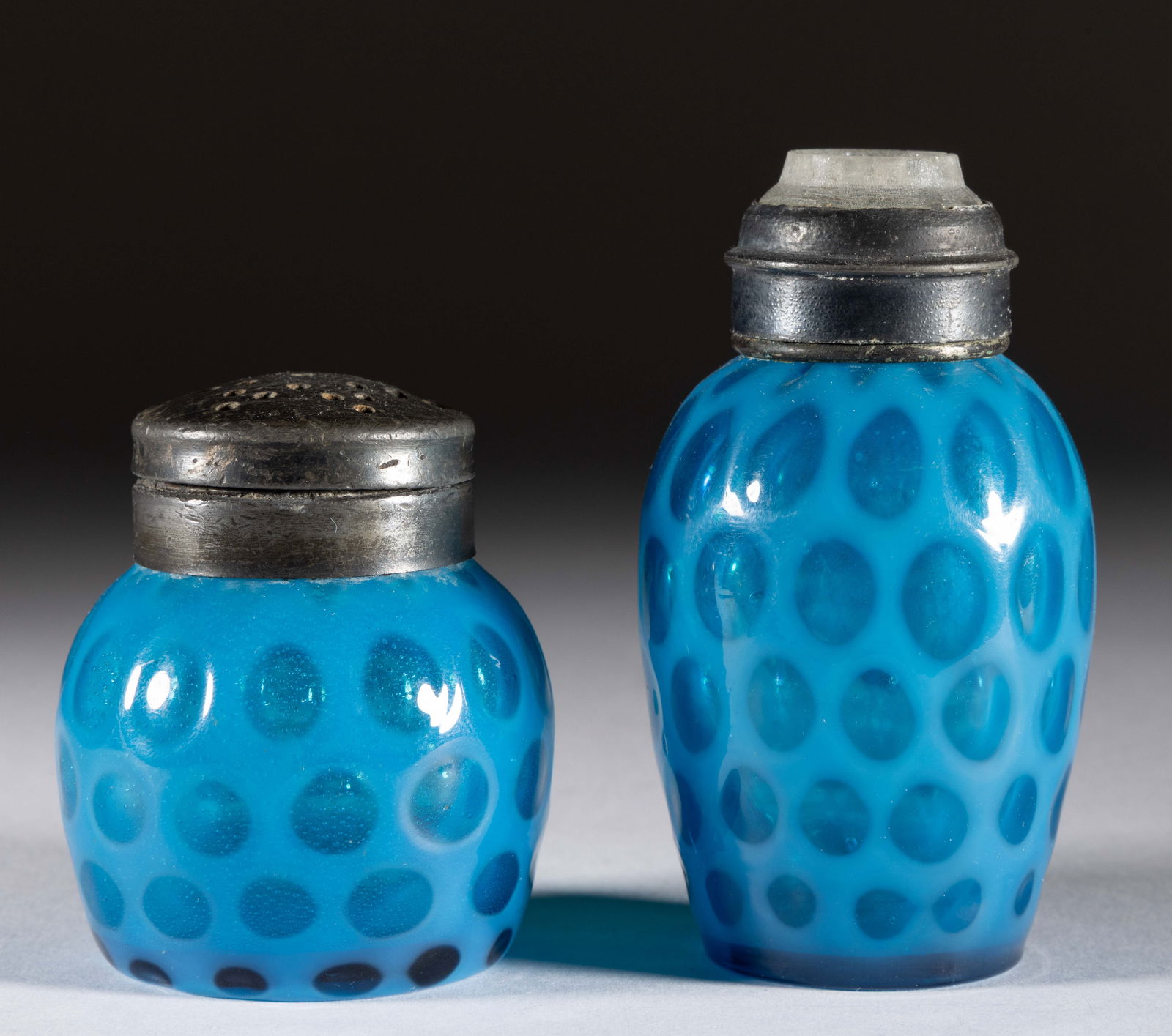 WINDOWS OPALESCENT GLASS SALT AND PEPPER SHAKER: WINDOWS OPALESCENT GLASS SALT AND PEPPER SHAKER, blue opalescent, comprising a tall and squat form example, each having a period lid with the taller example having a glass insert. Probably Phoenix Gla