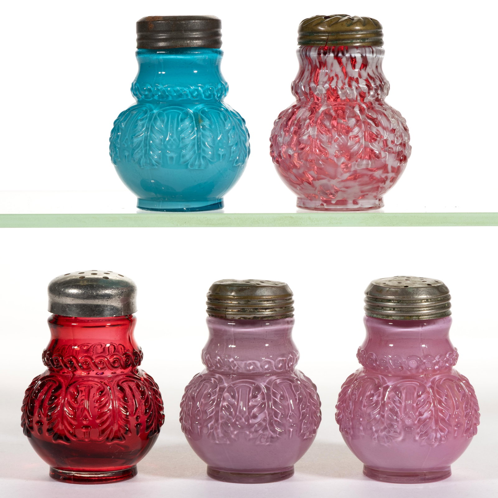 NORTHWOOD NO. 263 / LEAF UMBRELLA SALT AND PEPPER SHAKERS, LOT OF FIVE: NORTHWOOD NO. 263 / LEAF UMBRELLA SALT AND PEPPER SHAKERS, LOT OF FIVE, comprising two Rose du Berry, one Turquoise, a cranberry spatter, and a cased cranberry, each having a period lid. Northwoo
