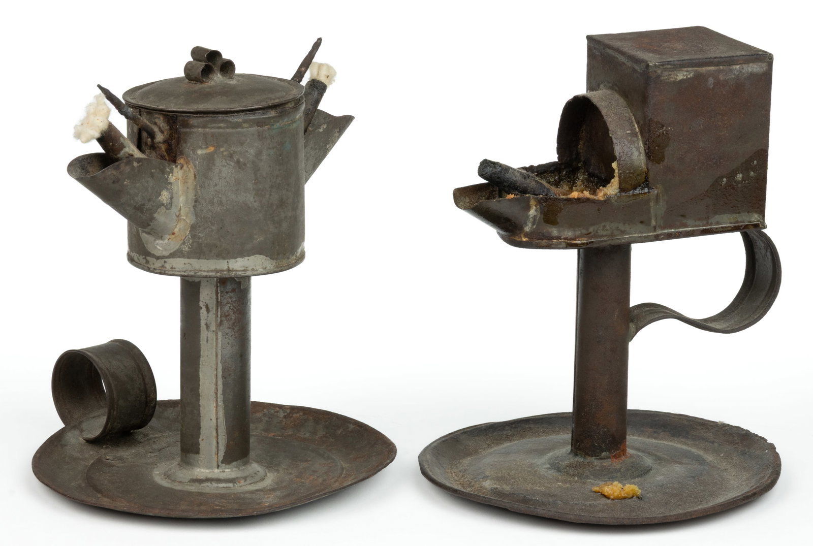 ASSORTED SHEET-IRON GREASE / FAT SAUCER-BASE LAMPS, LOT OF TWO: ASSORTED SHEET-IRON GREASE / FAT SAUCER-BASE LAMPS, LOT OF TWO, comprising a Portsmouth-type Betty-lamp example, square-form reservoir with contoured feeding chamber and large wick, strap handle 