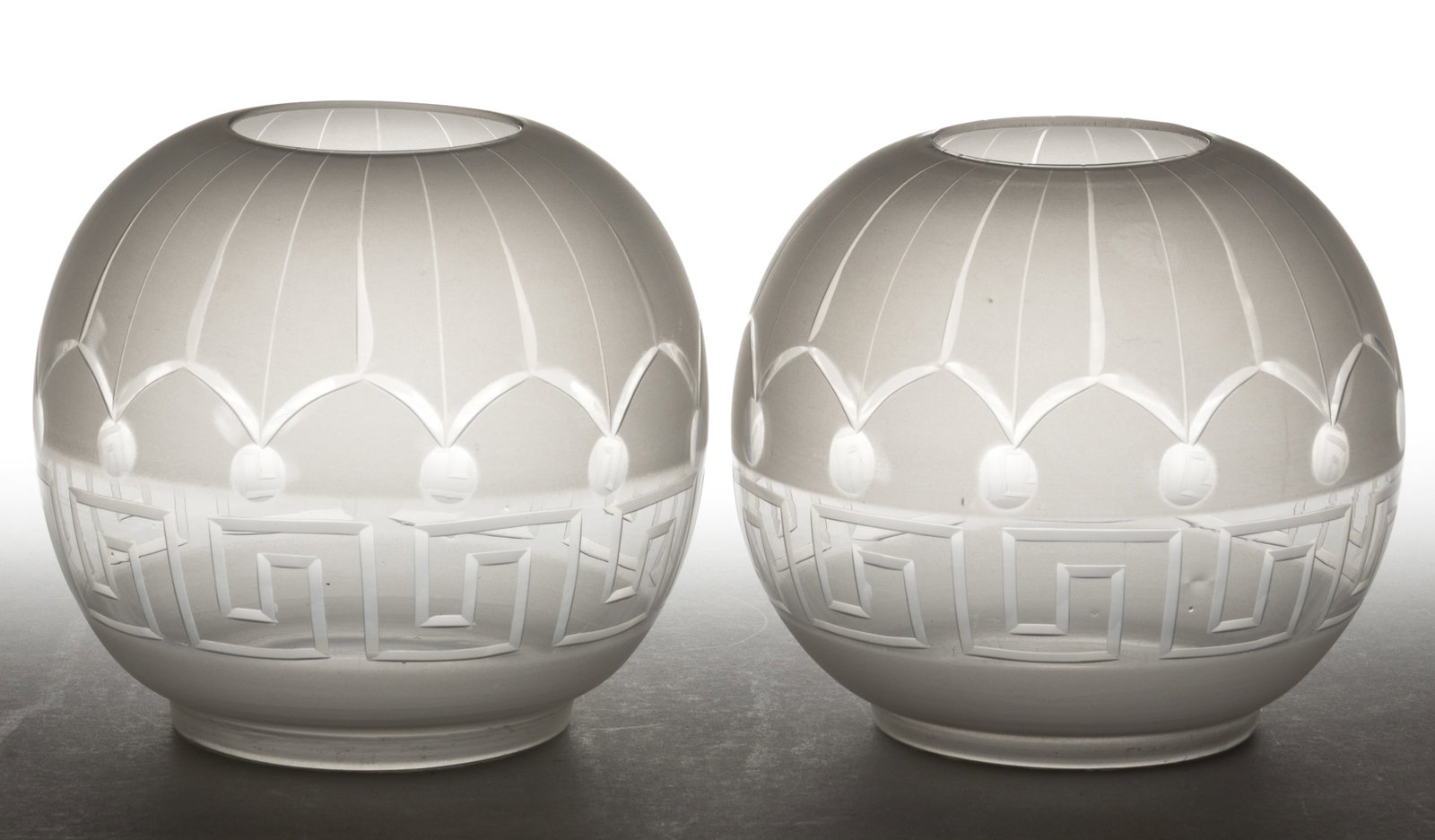 CUT AND ENGRAVED GREEK-KEY PATTERNED KEROSENE LAMP SHADES, PAIR: CUT AND ENGRAVED GREEK-KEY PATTERNED KEROSENE LAMP SHADES, PAIR, colorless with frosted finish, ball form, Greek Key band under a stylized arch band and punties. Fourth quarter 19th/early 20th ce