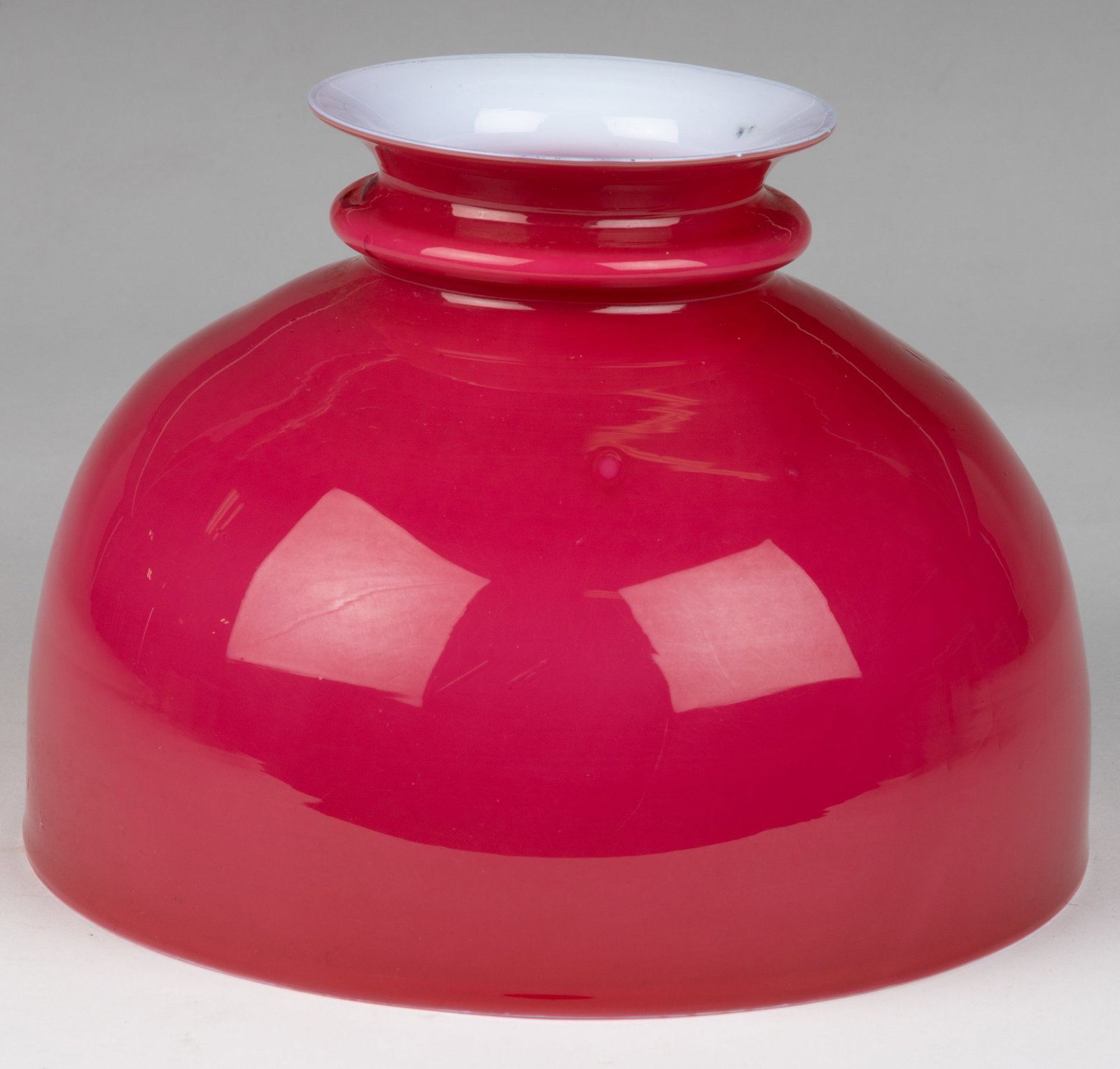 CASED GLASS KEROSENE LAMP SHADE: CASED GLASS KEROSENE LAMP SHADE, cased fuchsia/dark rose, umbrella form with ringed neck and flared rim. Late 19th/first quarter 20th century. 7 1/4" H, 10 1/8" D fitter, 4 7/8&quo