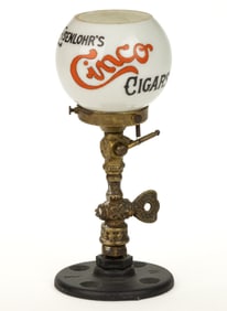 CAST-BRASS AND IRON COUNTER-TOP GAS CIGAR LIGHTER WITH EISENLOHR'S CINCO CIGARS GLASS SHADE