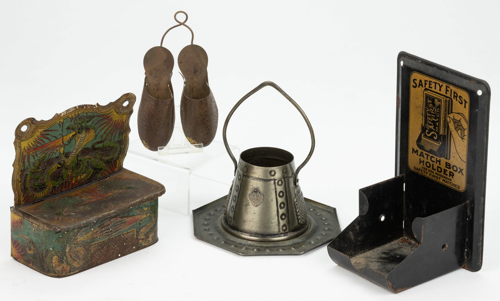 ASSORTED TIN AND METAL MATCH HOLDERS, LOT OF FOUR: ASSORTED TIN AND METAL MATCH HOLDERS, LOT OF FOUR, comprising a black-painted wall mount example with lithograph label "SAFETY FIRST"; a stamped embossed wall-mount example with decorated se