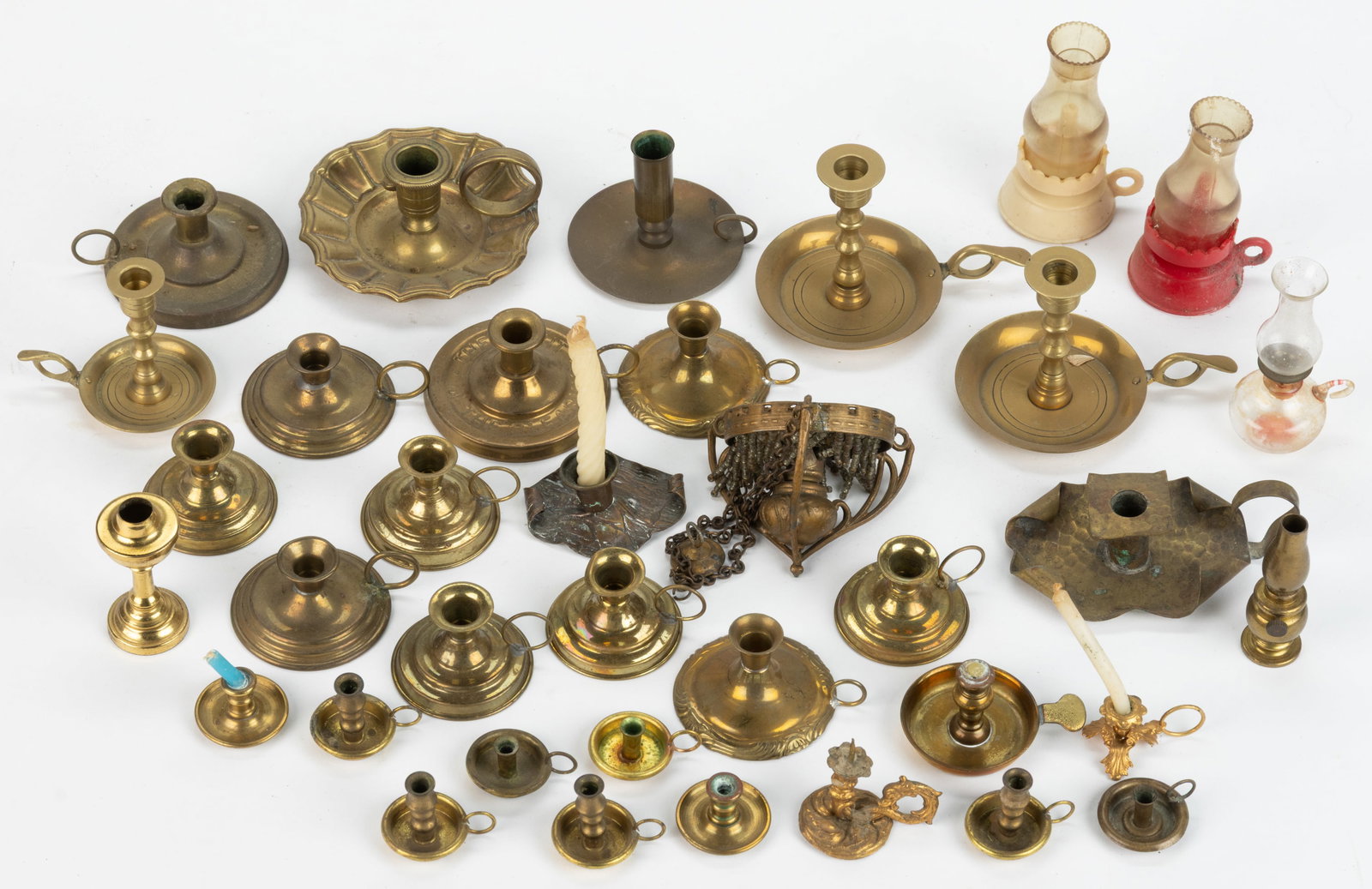 ASSORTED BRASS AND METAL DOLLHOUSE MINIATURE CANDLESTICKS AND RELATED, UNCOUNTED LOT: ASSORTED BRASS AND METAL DOLLHOUSE MINIATURE CANDLESTICKS AND RELATED, UNCOUNTED LOT, including approximately 30 brass chamberstick examples, two oil lamps, and a hanging oil lamp chandelier with bead