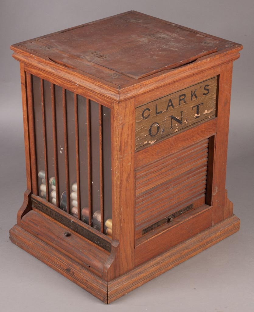 CLARK'S O.N.T. OAK SPOOL CABINET: CLARK'S O.N.T. OAK SPOOL CABINET, top load with roll-up tambour on two sides, original labels on all four sides. First quarter 20th century. 22 1/2" H, 16 1/2" x 20 1/2" base. Provenance: From the col