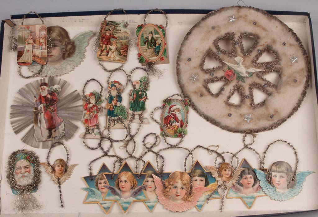 GERMAN DIE-CUT CHRISTMAS DECORATIONS, LOT OF 20: GERMAN DIE-CUT CHRISTMAS DECORATIONS, LOT OF 20, lithographed paper, cotton and tinsel, including green, blue and red suit Santa Clauses. Late 19th/early 20th century. Largest 10 1/4" D. Provenance: F
