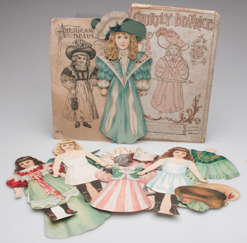 VICTORIAN PAPER DOLLS, TWO SETS: VICTORIAN PAPER DOLLS, TWO SETS, comprising Raphael Tuck "Courtly Beatrice" and "American Beauties", two original envelopes. Fourth quarter 19th/early 20th century. 8 1/2" and 10" H. Provenance: From 
