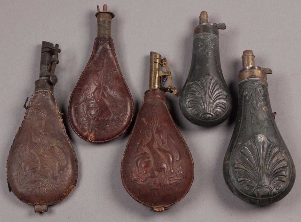 EMBOSSED AND TOOLED SHOT FLASKS / POUCHES, LOT OF FIVE: EMBOSSED AND TOOLED SHOT FLASKS / POUCHES, LOT OF FIVE, comprising three leather and two steel. 19th century. 6 1/4" to 8 3/4" L. Provenance: From the collection of the late Betty Jane Renn, Sunbury, 