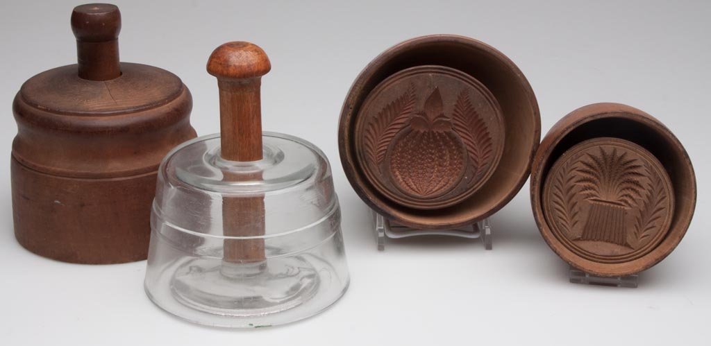 ASSORTED WOODEN AND GLASS BUTTER MOLDS, LOT OF FOUR: ASSORTED WOODEN AND GLASS BUTTER MOLDS, LOT OF FOUR, comprising three wooden examples with pineapple, sheaf of wheat and acorn patterns, two with 1866 patent dates, and a glass example with cow design