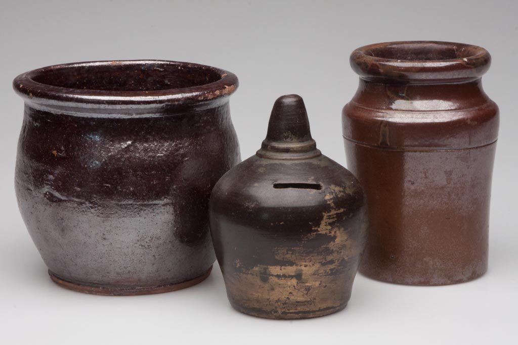 ASSORTED AMERICAN POTTERY ARTICLES, LOT OF THREE: ASSORTED AMERICAN POTTERY ARTICLES, LOT OF THREE, comprising an Albany-slip-glazed stoneware bank, a brown-glazed stoneware diminutive crock, and a lead and manganese-glazed pint crock. Second half 19
