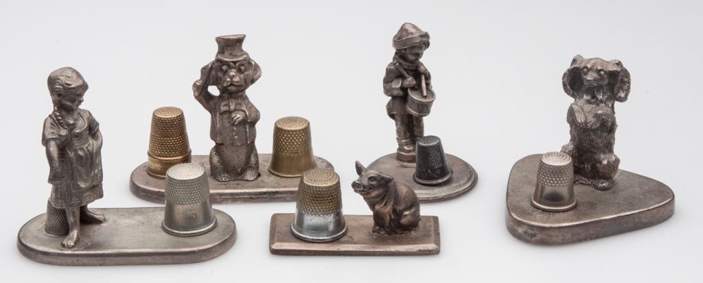 VICTORIAN-STYLE FIGURAL THIMBLE STANDS, LOT OF FIVE: VICTORIAN-STYLE FIGURAL THIMBLE STANDS, LOT OF FIVE, comprising children and animals, base markings include Britannia, Gem and G&D. Probably 20th century. 1 1/8" to 2 3/8" H. Provenance: The collectio