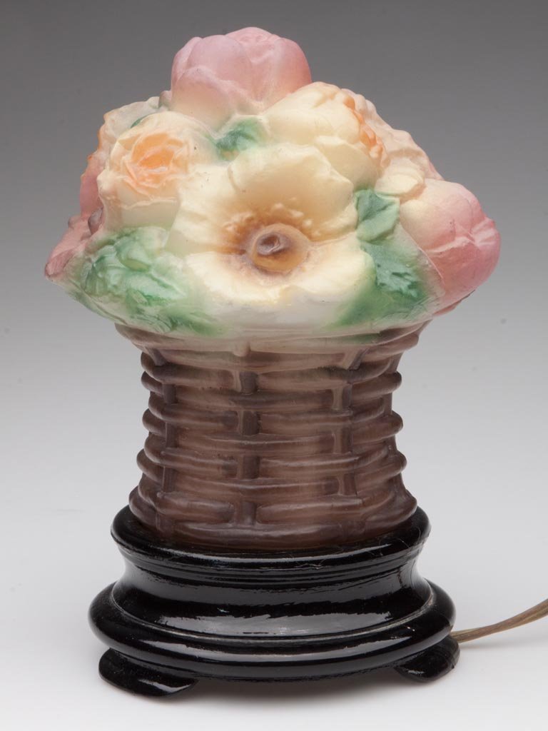 TIFFIN FLOWER BASKET GLASS NOVELTY LAMP: TIFFIN FLOWER BASKET GLASS NOVELTY LAMP, frosted puffy floral shade with polychrome decoration, screws into an opaque black base. United States Glass Co., Pittsburgh, PA. Circa 1925. 7 1/2" HOA. Prove