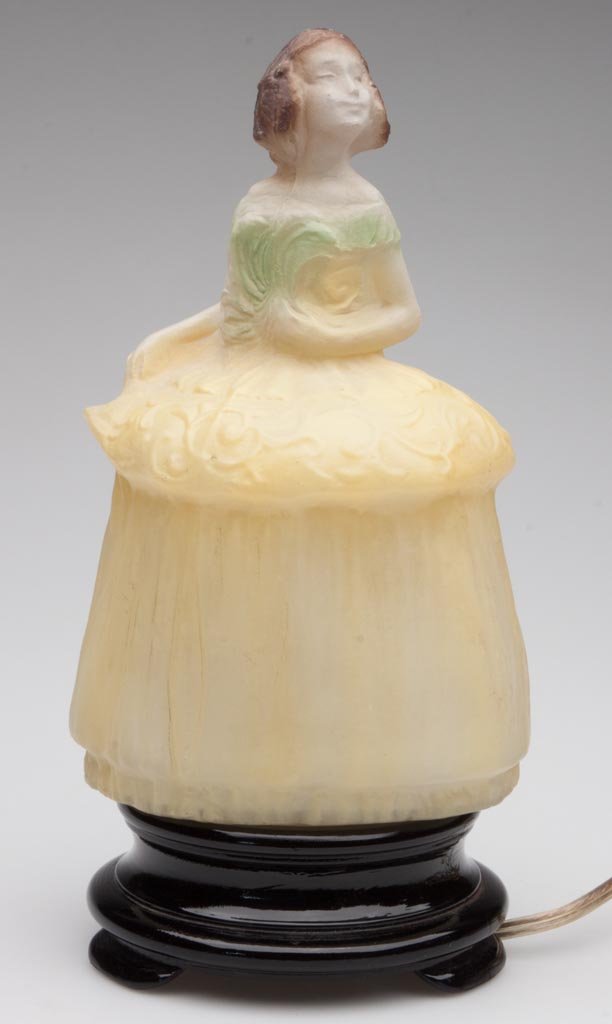 TIFFIN COLONIAL DAME / CRINOLINE GIRL GLASS NOVELTY LAM: TIFFIN COLONIAL DAME / CRINOLINE GIRL GLASS NOVELTY LAMP, frosted shade with polychrome decoration, screws into an opaque black base. United States Glass Co., Pittsburgh, PA. Circa 1925. 9 1/2" H. Pro