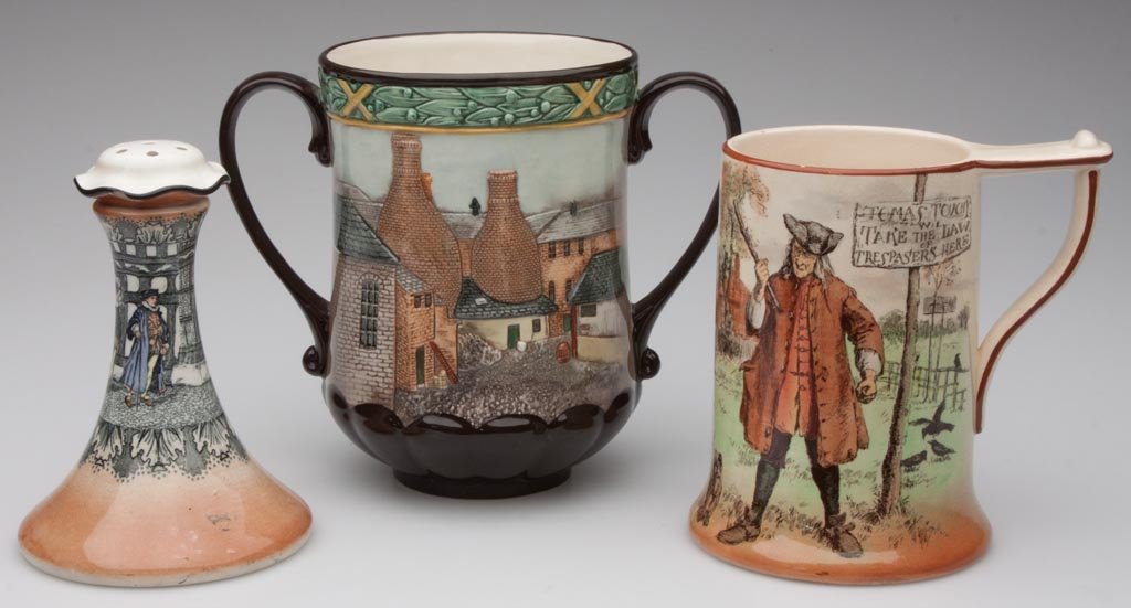 ROYAL DOULTON SERIES WARE ARTICLES, LOT OF THREE: ROYAL DOULTON SERIES WARE ARTICLES, LOT OF THREE, comprising a "Pottery in the Past" loving cup, No. D6696; a hatpin holder, possibly "Henry VIII at Hampton Court", No. D3858; and a "Thomas Touchy" ta