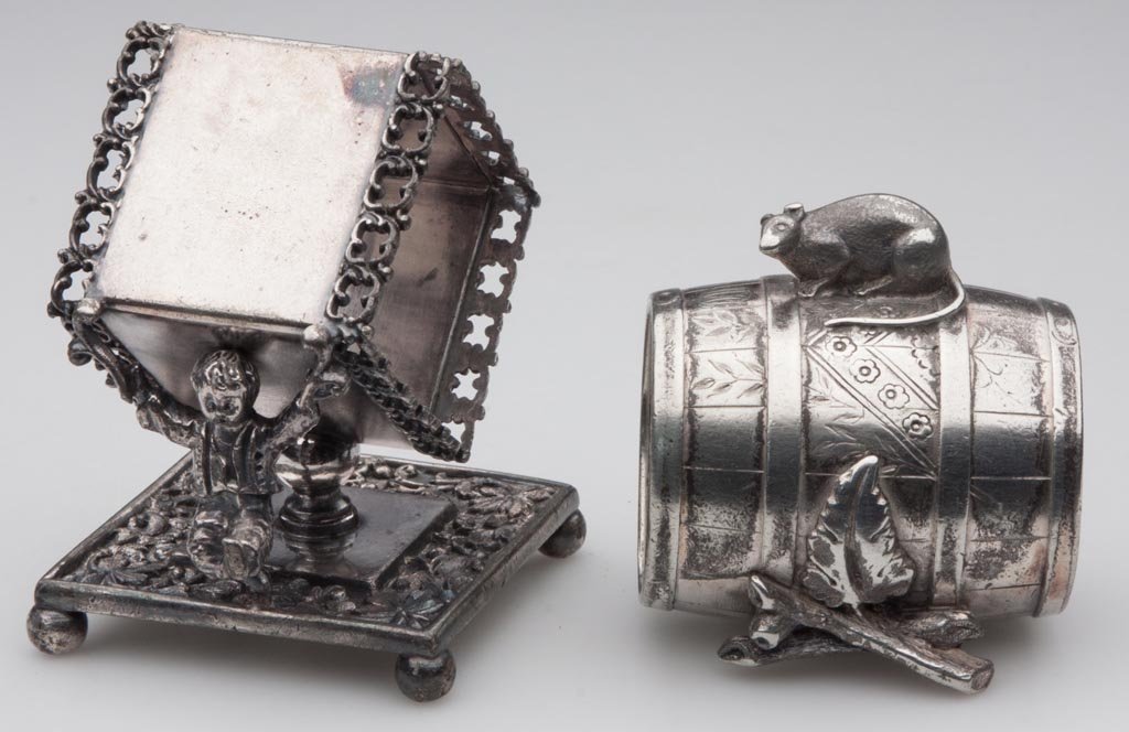 VICTORIAN QUADRUPLE-PLATE FIGURAL NAPKIN RINGS, LOT OF : VICTORIAN QUADRUPLE-PLATE FIGURAL NAPKIN RINGS, LOT OF TWO, comprising a square Rogers & Smith example with a boy, and an unmarked barrel-form example with a mouse. Fourth quarter 19th century. 2 1/4"