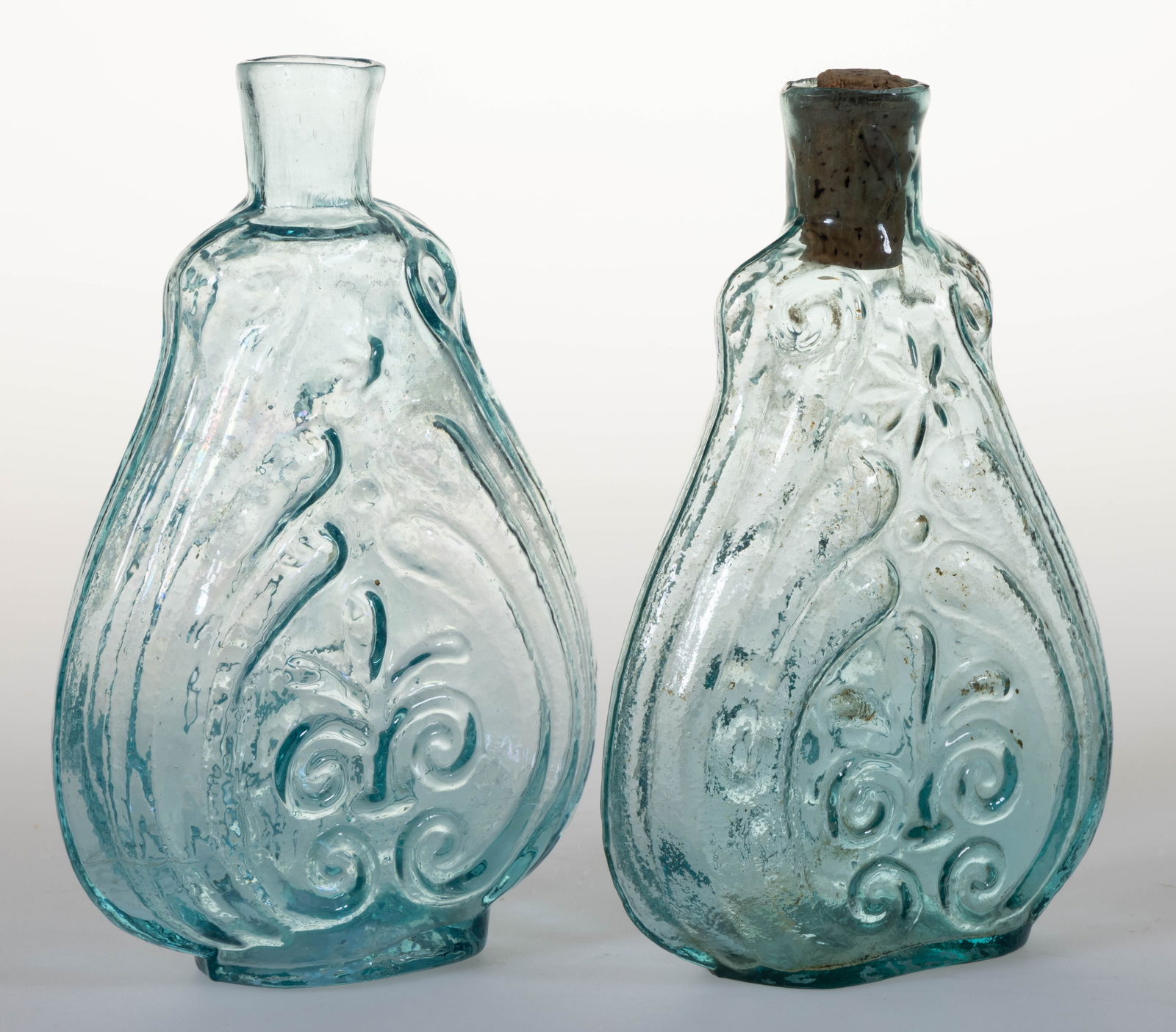 ASSORTED HALF PINT SIZED SCROLL FIGURED HISTORICAL FLASKS, LOT OF TWO: ASSORTED HALF PINT SIZED SCROLL FIGURED HISTORICAL FLASKS, LOT OF TWO, aquamarine, comprising a GXII-34 and a GXII-37, each with straight sheared and tooled mouths and rough pontil marks to