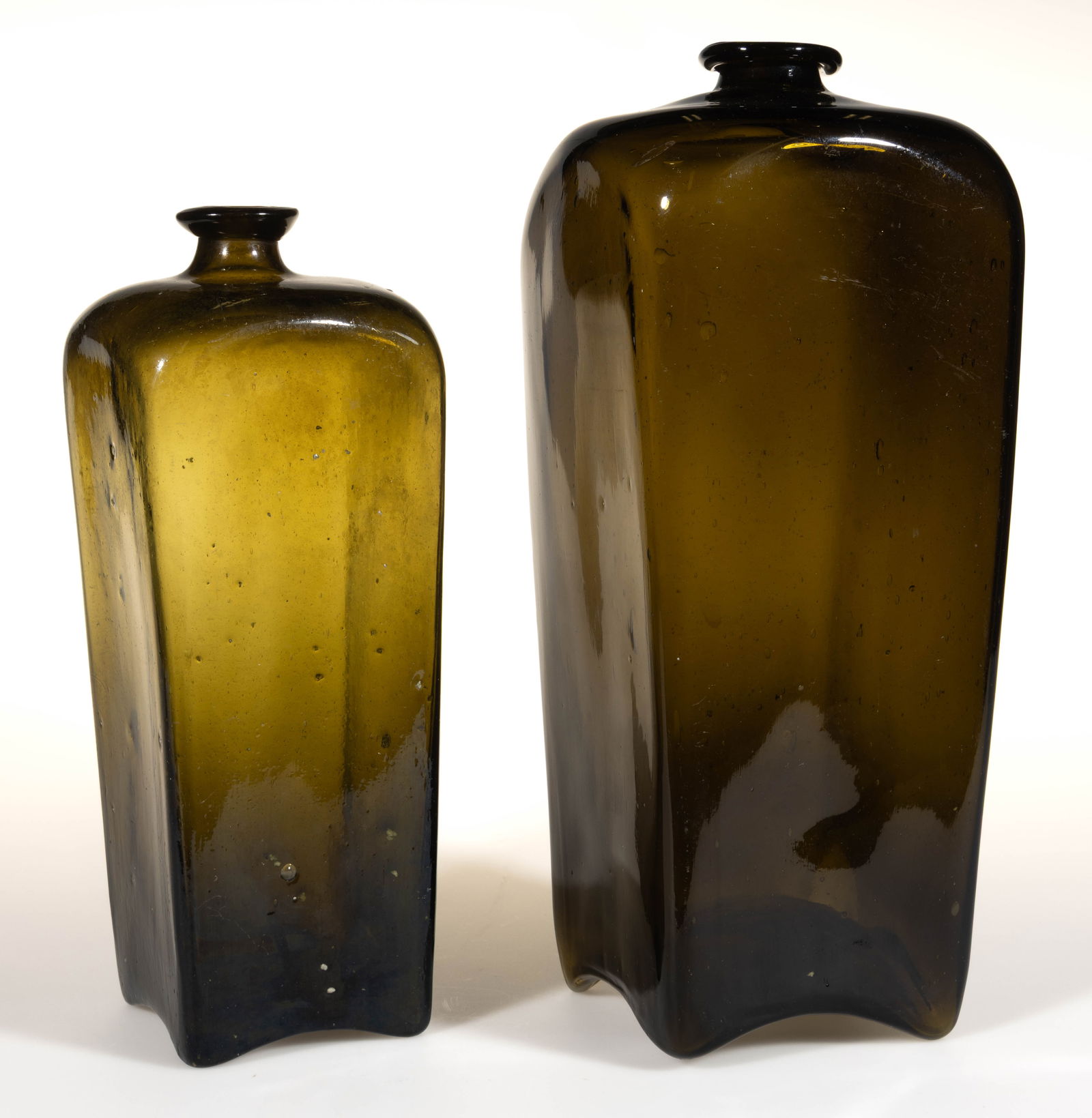 DUTCH FREE-BLOWN BLACK GLASS CASE GIN BOTTLES, LOT OF TWO: DUTCH FREE-BLOWN BLACK GLASS CASE GIN BOTTLES, LOT OF TWO, medium-to-dark olive green/black glass, early square "case bottle" form with slight inward taper, applied outwardly-flaring so-call