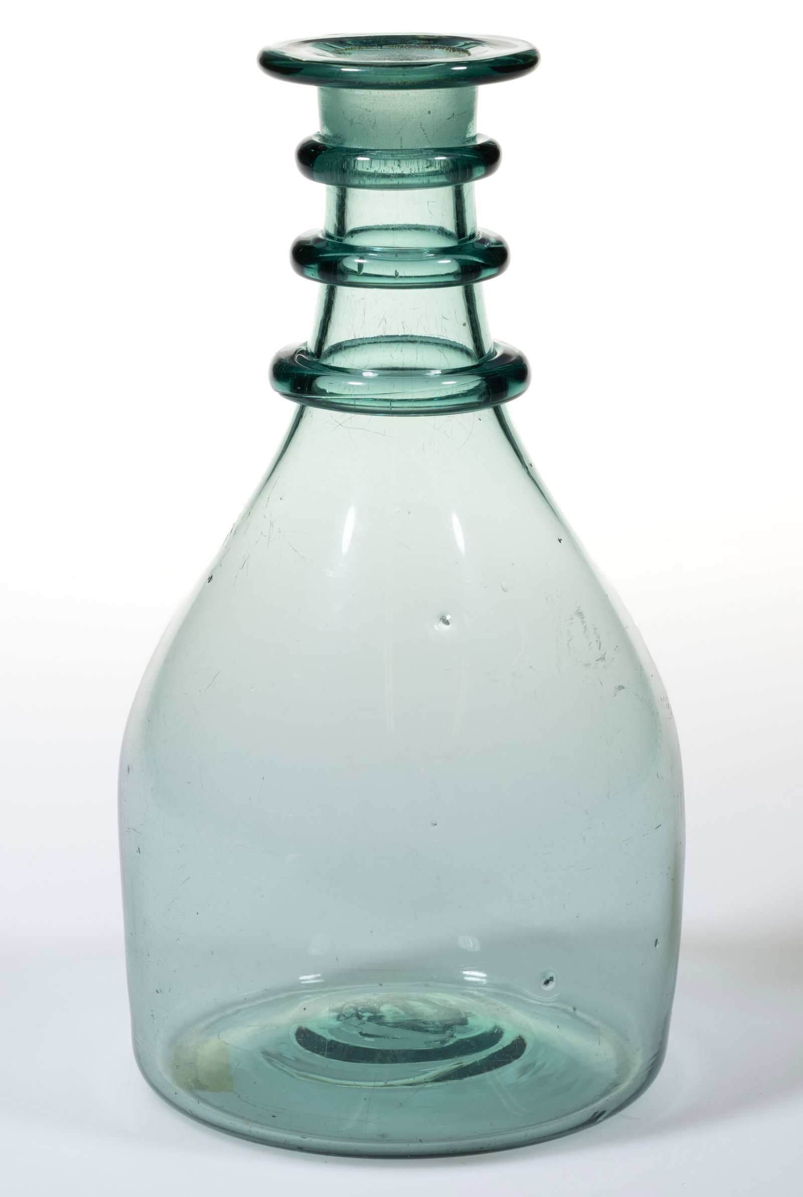 AMERICAN FREE-BLOWN GLASS RING-NECKED DECANTER / BOTTLE: AMERICAN FREE-BLOWN GLASS RING-NECKED DECANTER / BOTTLE, greenish aquamarine, free-blown Prussian form with three round applied neck rings below the tooled/flared and flattened mouth, interior of neck