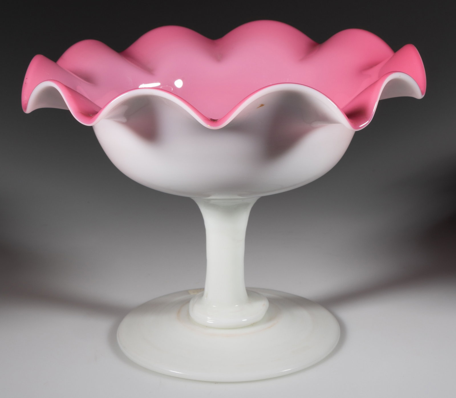 SANDWICH LATE BLOWN GLASS COMPOTE / FOOTED BOWL: SANDWICH LATE BLOWN GLASS COMPOTE / FOOTED BOWL, the ruffled-rim round opal bowl having a rose/pink cased interior, raised on an opal foot and solid straight stem, rough pontil mark to under