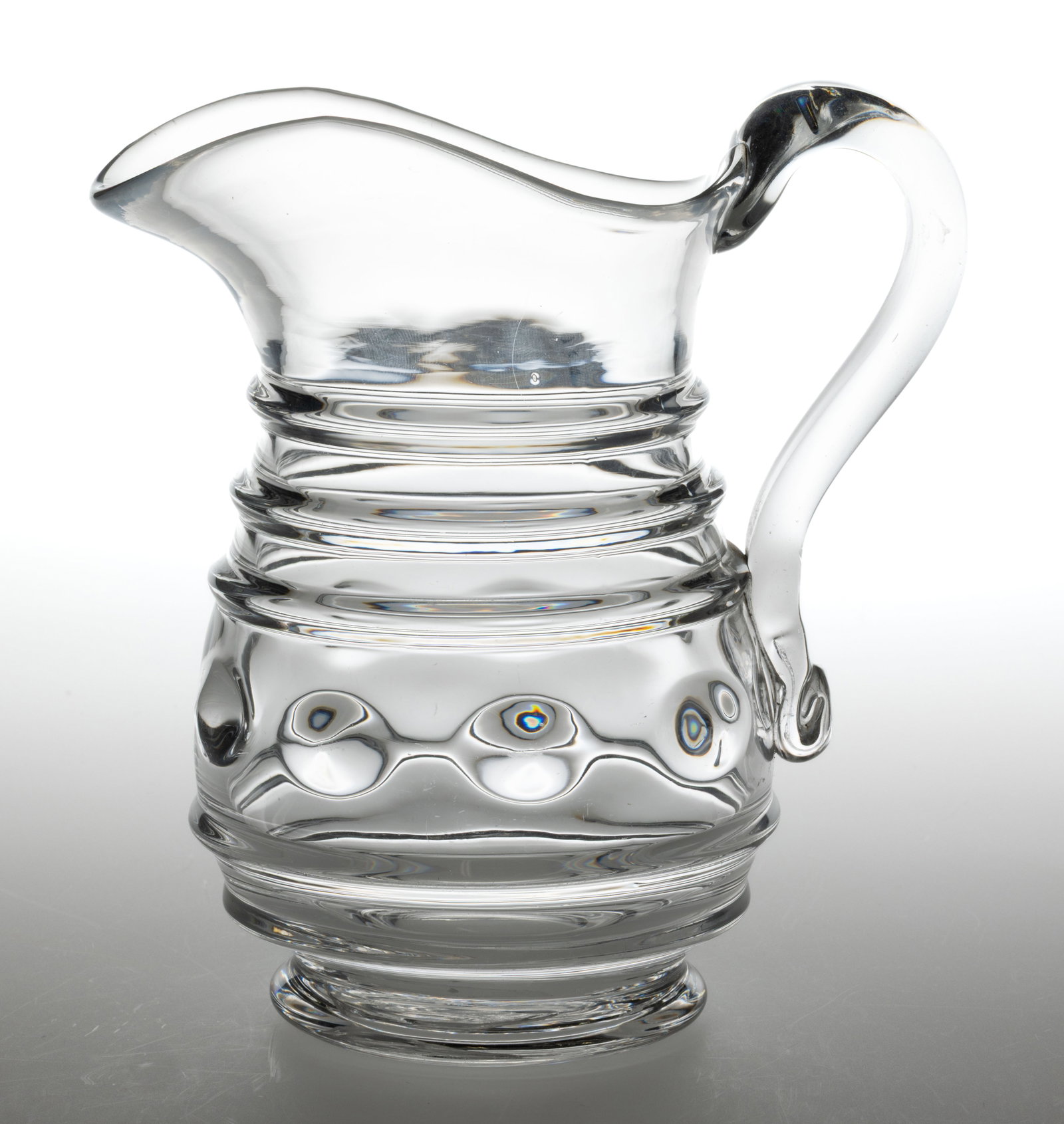 BLOWN-MOLDED RING AND LENS QUART JUG / MILK PITCHER: BLOWN-MOLDED RING AND LENS QUART JUG / MILK PITCHER, colorless lead glass, pyriform with five horizontal rings to the body and nine lens to the body, including one lens to the underside of l