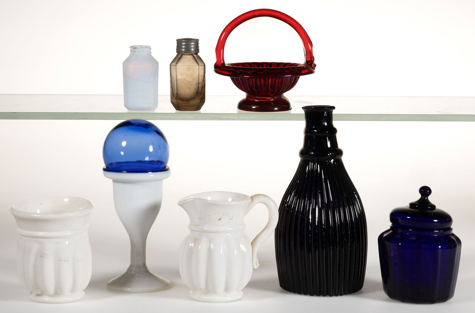 AMERICAN AND EUROPEAN FREE-BLOWN AND PATTERN-MOLDED GLASS ARTICLES, LOT OF TEN: AMERICAN AND EUROPEAN FREE-BLOWN AND PATTERN-MOLDED GLASS ARTICLES, LOT OF TEN, various colors, including an opaque white/opalescent egg cup with applied blue rim and a small well-fitting witch ball/c