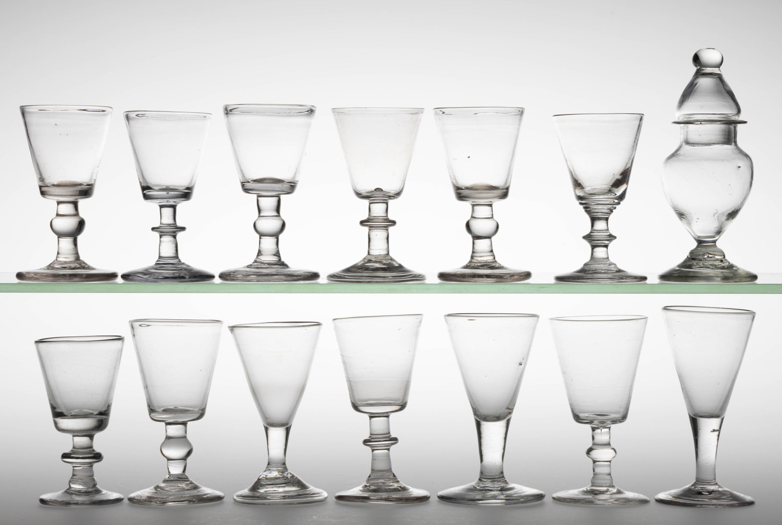 ASSORTED FREE-BLOWN TABLE AND DRINKING VESSELS, LOT OF 14: ASSORTED FREE-BLOWN TABLE AND DRINKING VESSELS, LOT OF 14, colorless, comprising of 13 wine glasses including five examples with a bladed knop stem, five examples with a ball-form knop stem, and 