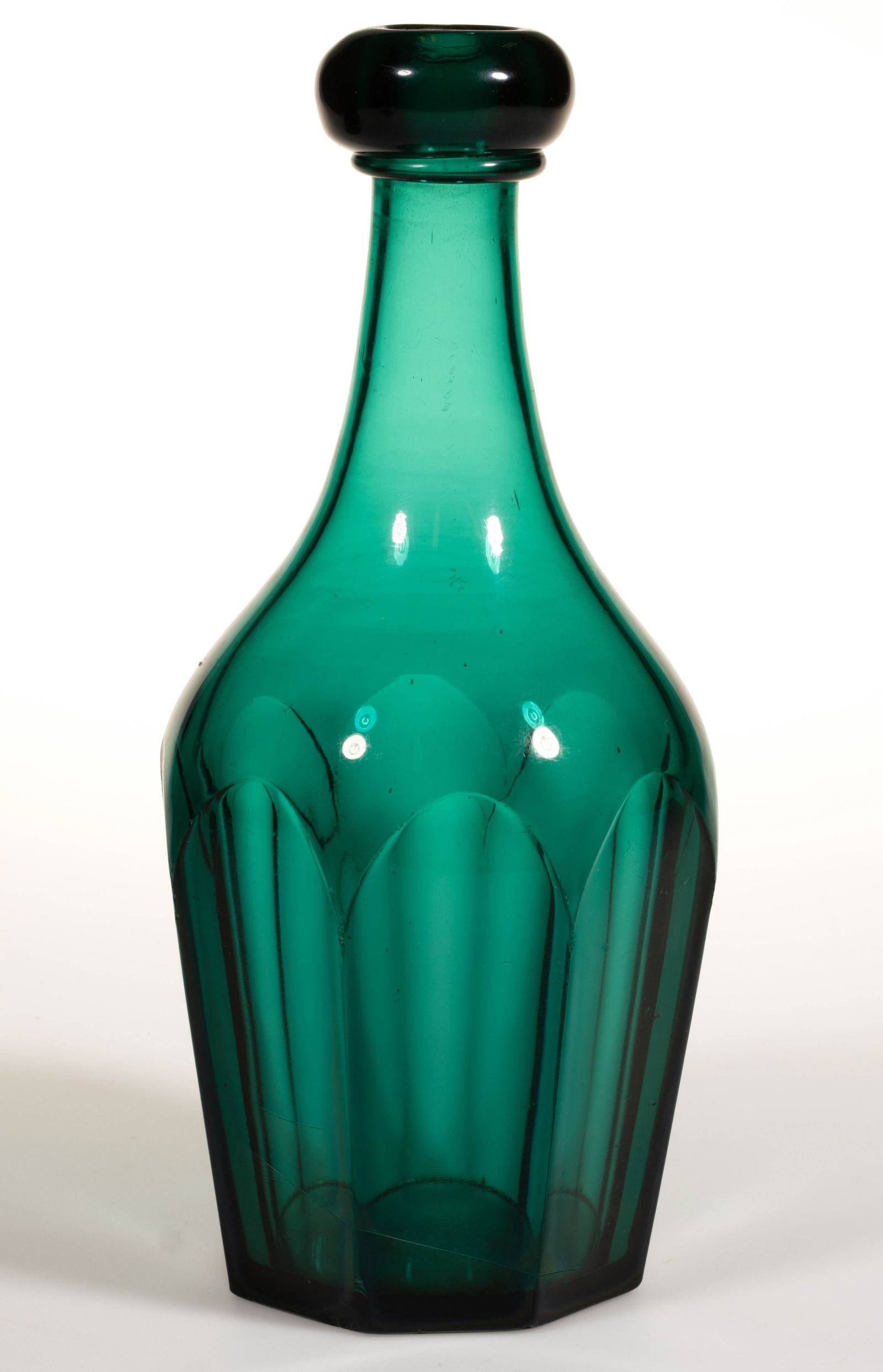 PRESSED EIGHT-FLUTE QUART BAR DECANTER: PRESSED EIGHT-FLUTE QUART BAR DECANTER, deep emerald green, applied bar lip, plain neck, underside of base with a polished pontil mark. New England or Pittsburgh area. 1850-1870. 10 1/2" H, 3 3/4