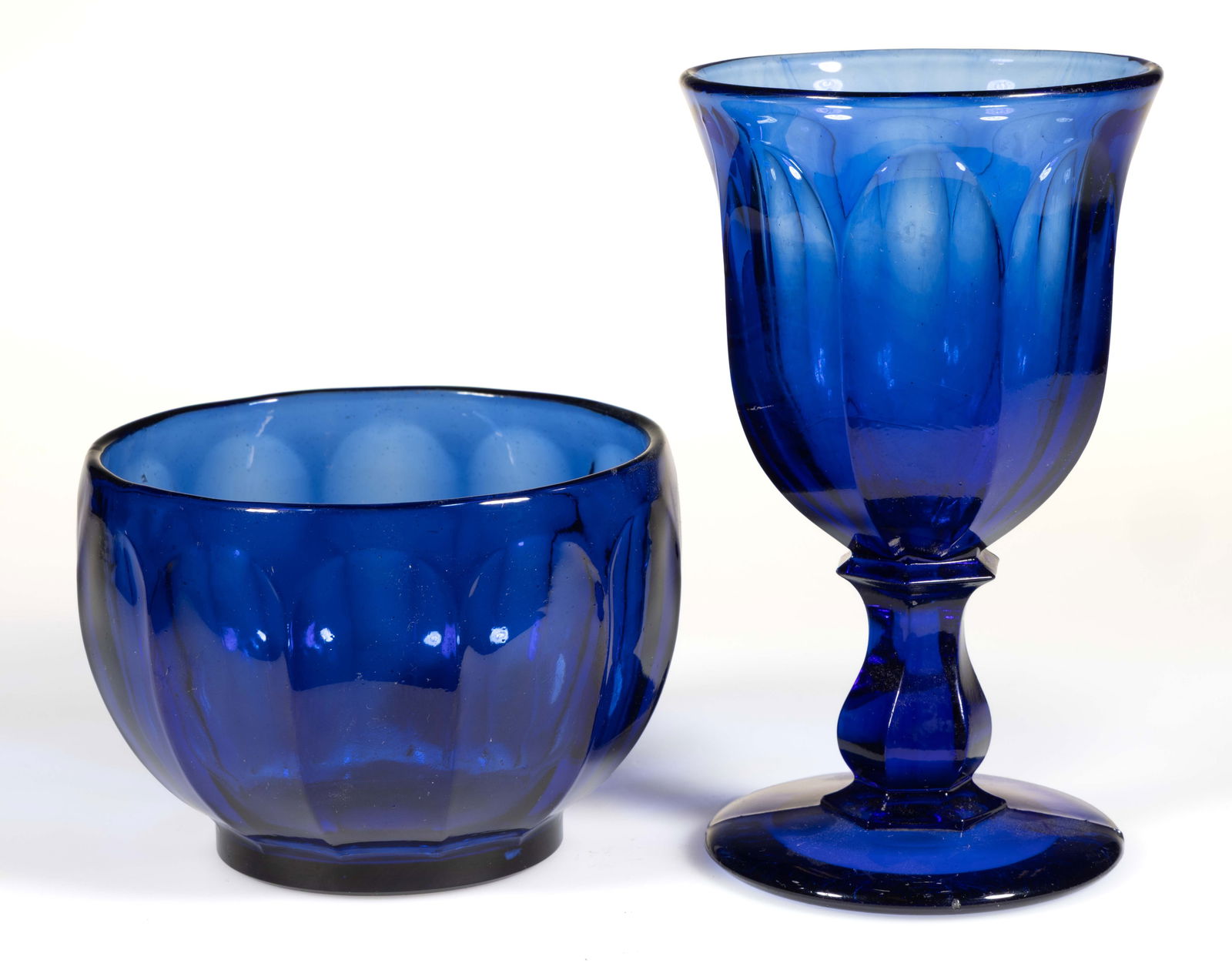 PRESSED FLUTE TABLE ARTICLES, LOT OF TWO: PRESSED FLUTE TABLE ARTICLES, LOT OF TWO, cobalt blue, comprising an Eight-Flute goblet with a hexagonal baluster-form stem and a circular foot with polished pontil mark, and a 12-Flute cupped-form fi