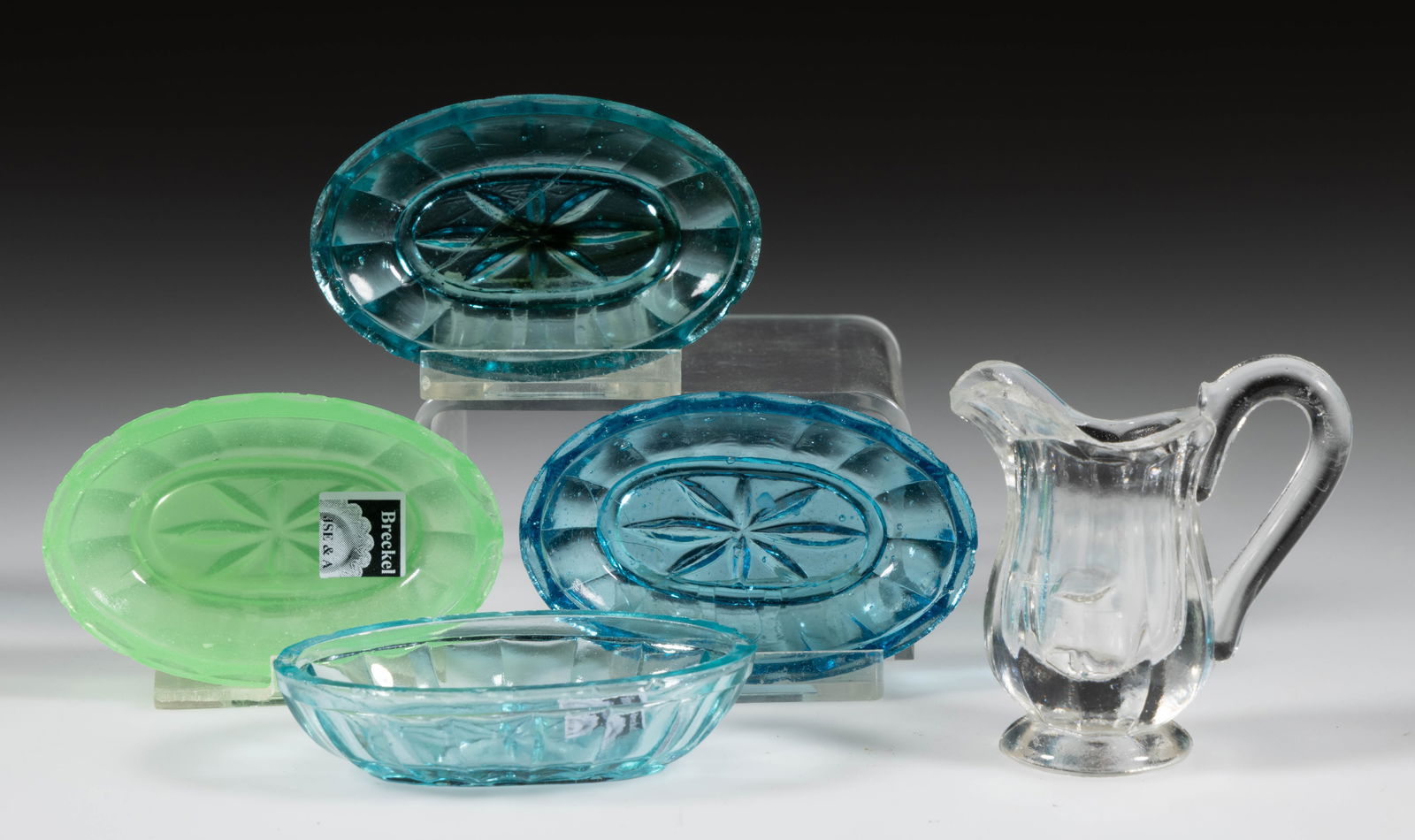 PRESSED PANELLED TOY ARTICLES, LOT OF FIVE: PRESSED PANELLED TOY ARTICLES, LOT OF FIVE, comprising oval dishes in translucent jade green and three different shades of blue, each with 16 panels below the plain rim and eight-point star base, and