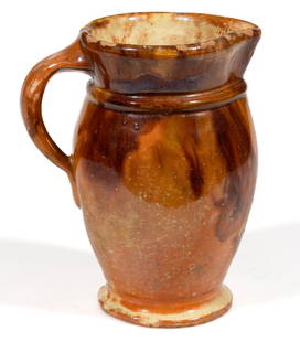 STRASBURG, VIRGINIA, SHENANDOAH VALLEY OF VIRGINIA DECORATED EARTHENWARE / REDWARE CREAM PITCHER: STRASBURG, VIRGINIA, SHENANDOAH VALLEY OF VIRGINIA DECORATED EARTHENWARE / REDWARE CREAM PITCHER, lead- and manganese-glazed over a slip wash, elongated ovoid form with&nbsp;tall rim, collared neck, a