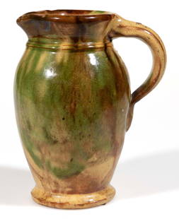 STRASBURG, SHENANDOAH VALLEY OF VIRGINIA POLYCHROME-DECORATED EARTHENWARE / REDWARE CREAMWARE: STRASBURG, SHENANDOAH VALLEY OF VIRGINIA POLYCHROME-DECORATED EARTHENWARE / REDWARE CREAMWARE PITCHER, lead-, copper-, and manganese-glazed over a slip wash,&nbsp;ovoid form with flared mouth, beaded