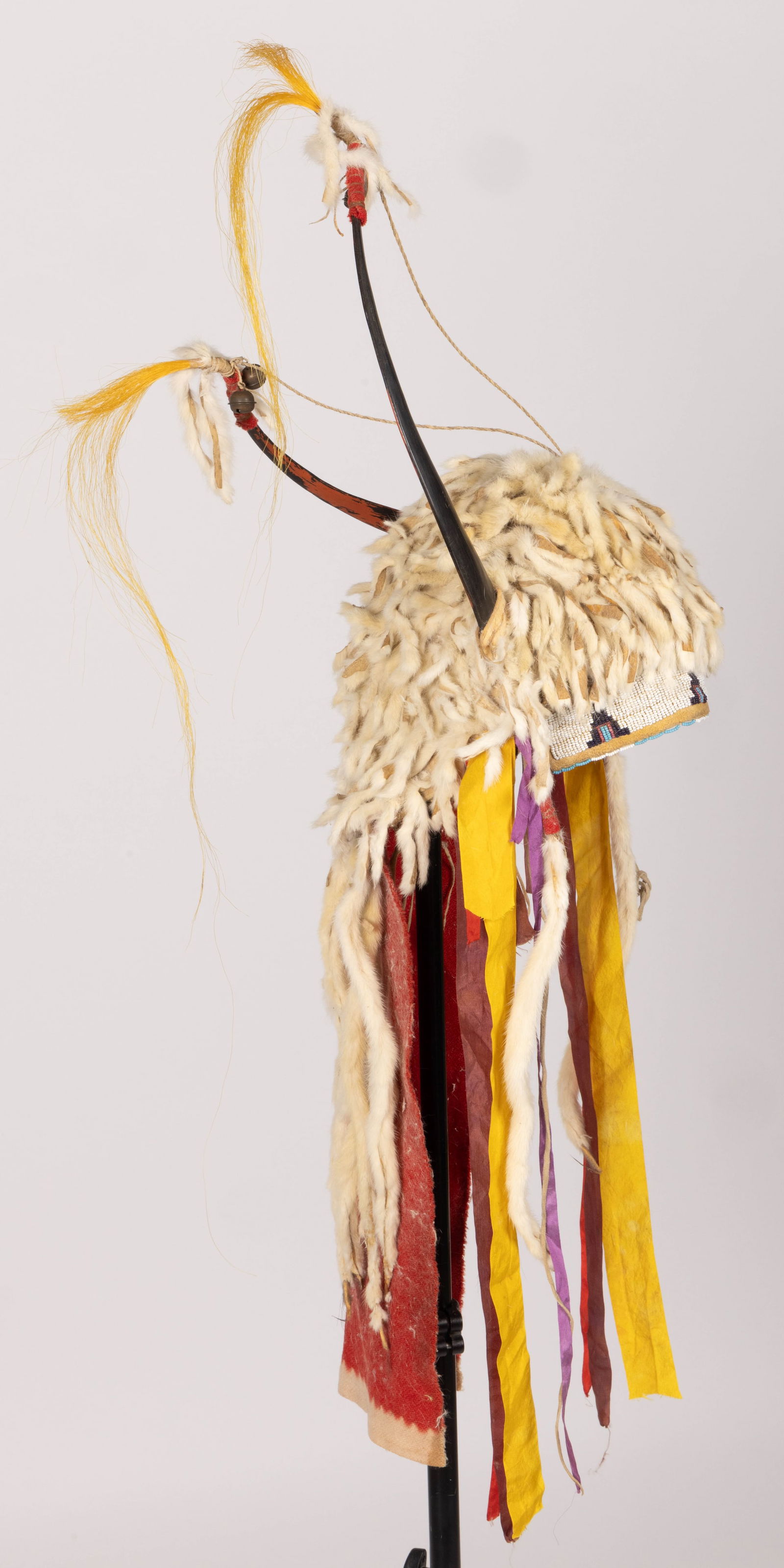 NATIVE AMERICAN PLAINS INDIAN SPLIT-HORN, ERMINE, AND BEADED HIDE HEADDRESS: NATIVE AMERICAN PLAINS INDIAN SPLIT-HORN, ERMINE, AND BEADED HIDE HEADDRESS, sinew sewn and other materials, headband featuring lane-stitched beading, top of cap completely covered in strips of ermine