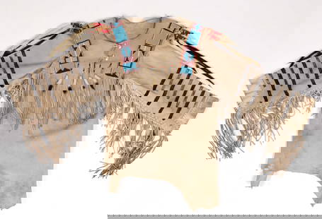 NATIVE AMERICAN MAN'S HIDE SHIRT WITH BEADING AND ERMINE TAILS: NATIVE AMERICAN MAN'S HIDE SHIRT WITH BEADING AND ERMINE TAILS, shirt sewn with leather cords having fringe accents, neck with partial opening and elk teeth buttons, long-sleeves with