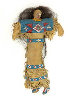 NATIVE AMERICAN NORTHERN PLAINS INDIAN BEADED HIDE WOMAN DOLL: NATIVE AMERICAN NORTHERN PLAINS INDIAN BEADED HIDE WOMAN DOLL, thread sewn, having a stuffed hide body with beading to face and applied hair, wearing a hide dress with fringe and bands of