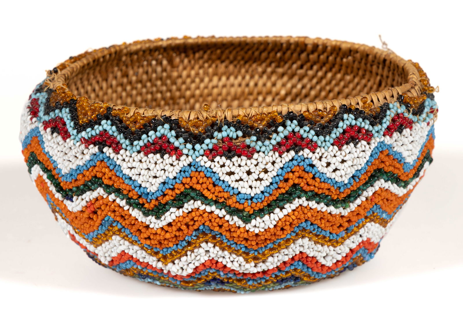 NATIVE AMERICAN GREAT BASIN BEADED WOVEN-COIL BASKET: NATIVE AMERICAN GREAT BASIN BEADED WOVEN-COIL BASKET, round form, exterior fully covered by thread-sewn polychrome beads in a concentric chevron/zig-zag pattern. Probably Northern Paiute / Washoe